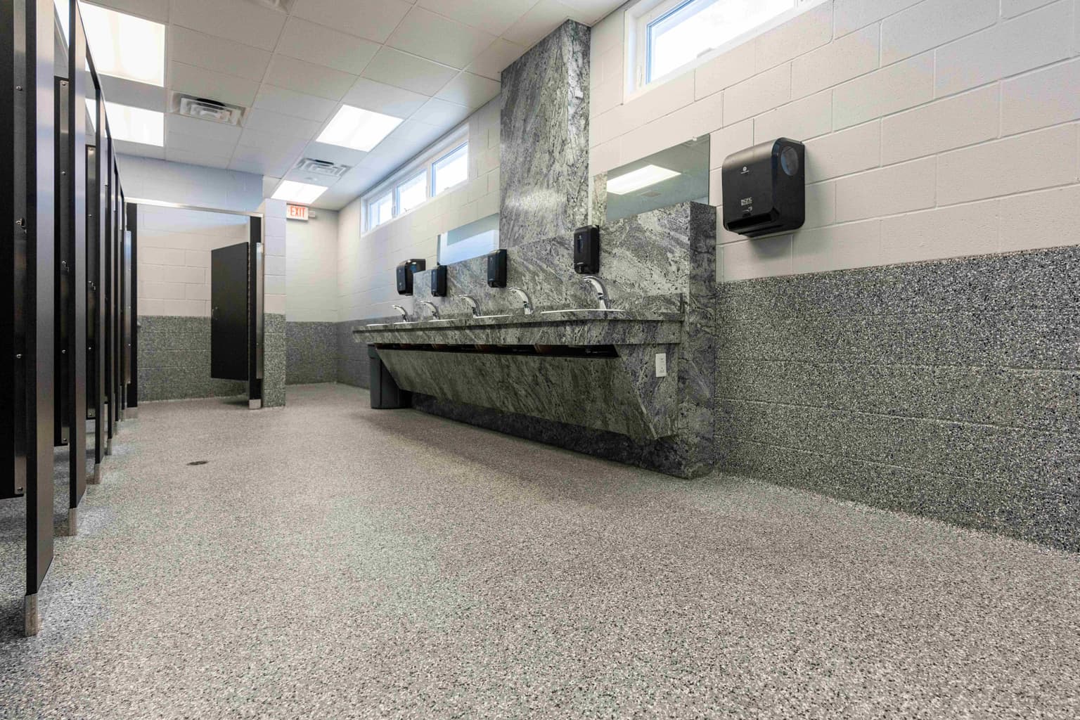 Modern commercial bathroom with polished concrete flooring